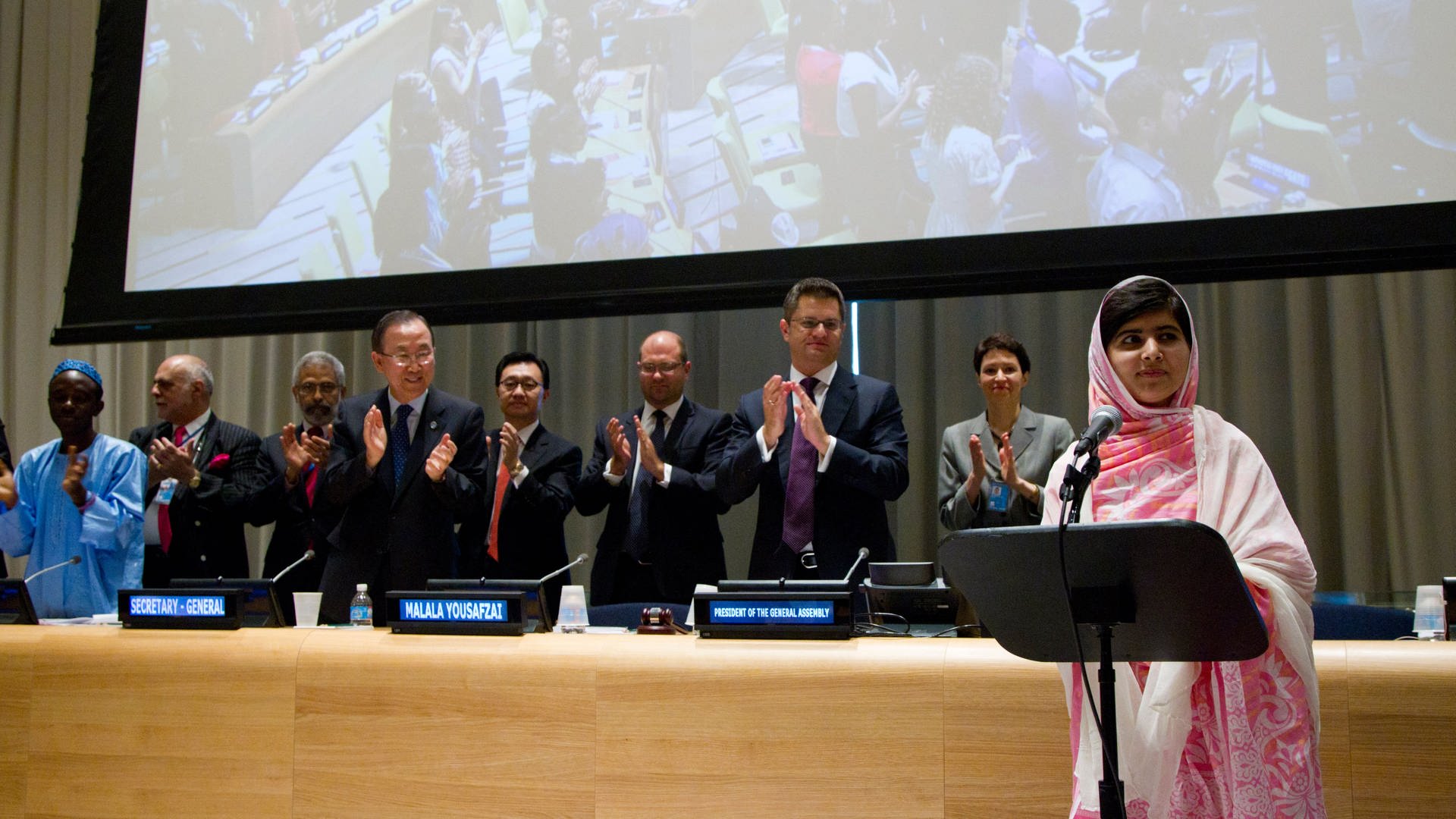 Nach der Rede von Malala über das Recht aller Kinder auf Bildung stehen die Menschen auf und klatschen Beifall.