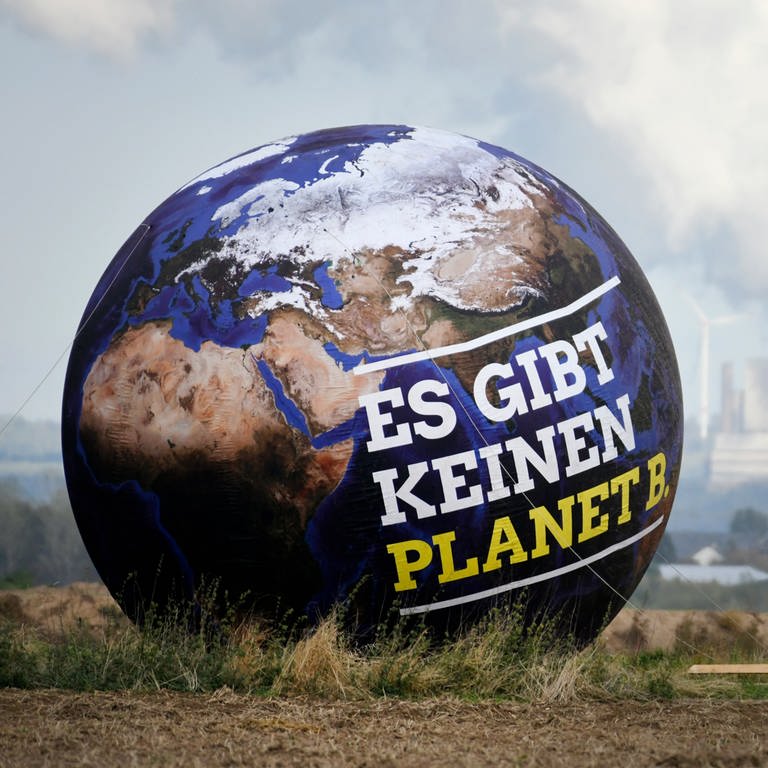 Ein Ballon mit der Aufschrift "Es gibt keinen Planet B." ist vor Braunkohlekraftwerken zu sehen.