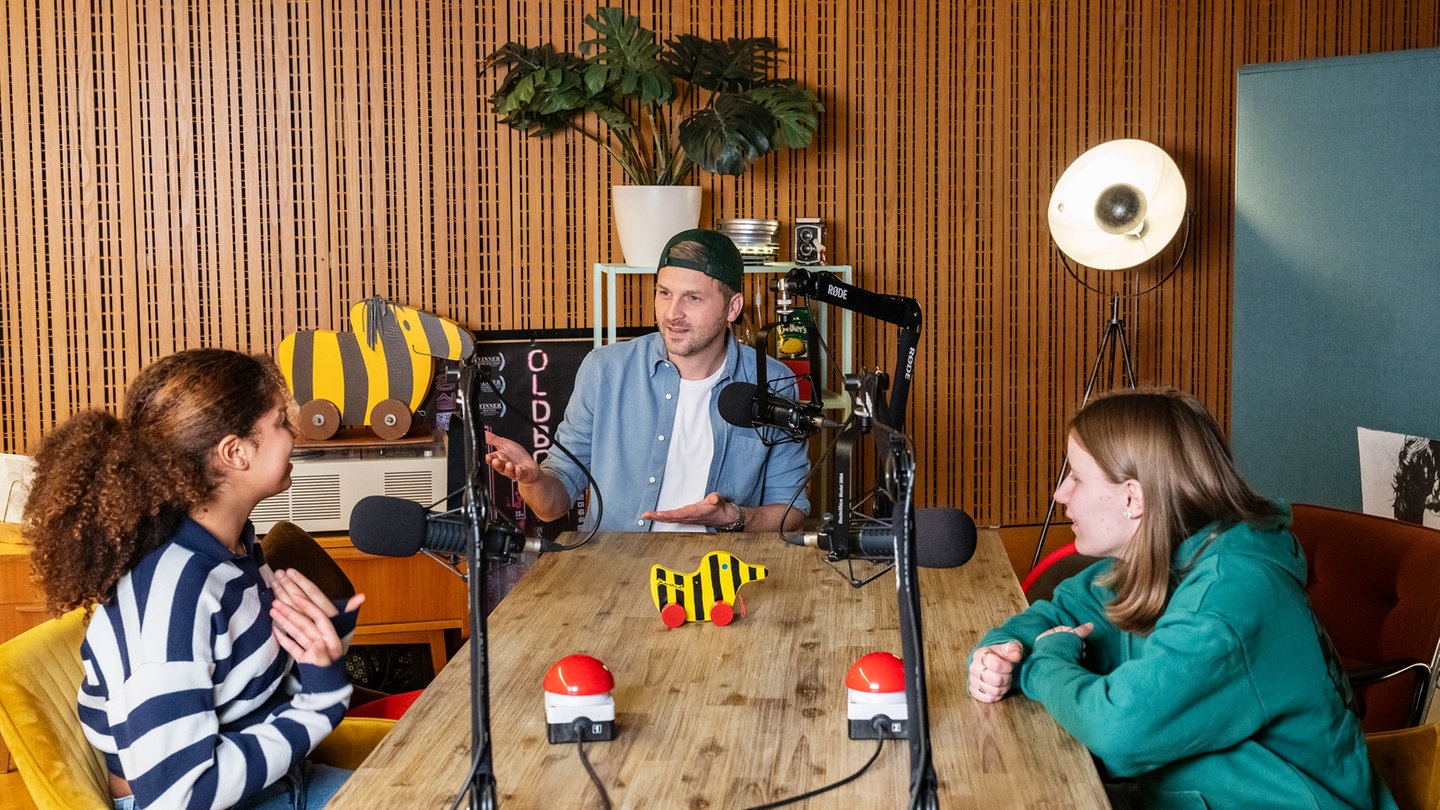 Johannes Zenglein begrüßt zwei Kinder im Podcast 