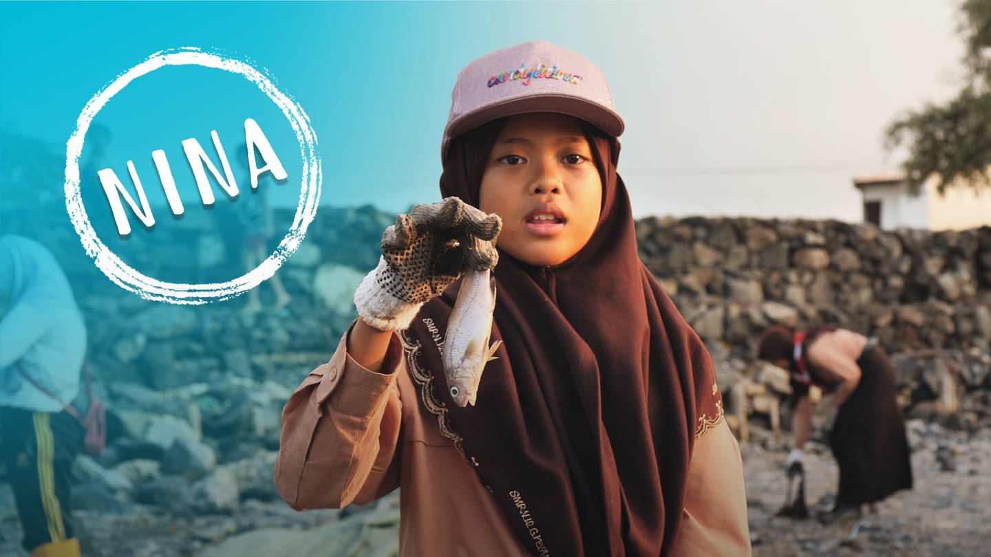 Mädchen hält toten Fisch in der Hand, um auf Umweltverschmutzung aufmerksam zu machen. (Foto: SWR)