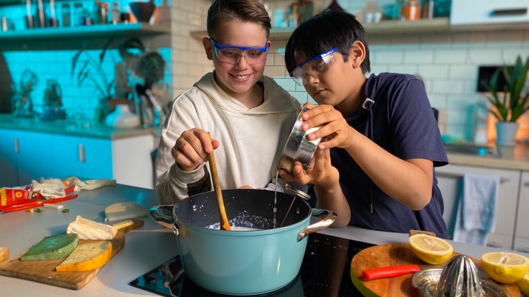 Emil und Lee gießen Zitrone in Milch für Frischkäse (Foto: SWR, Marike Hoppe)