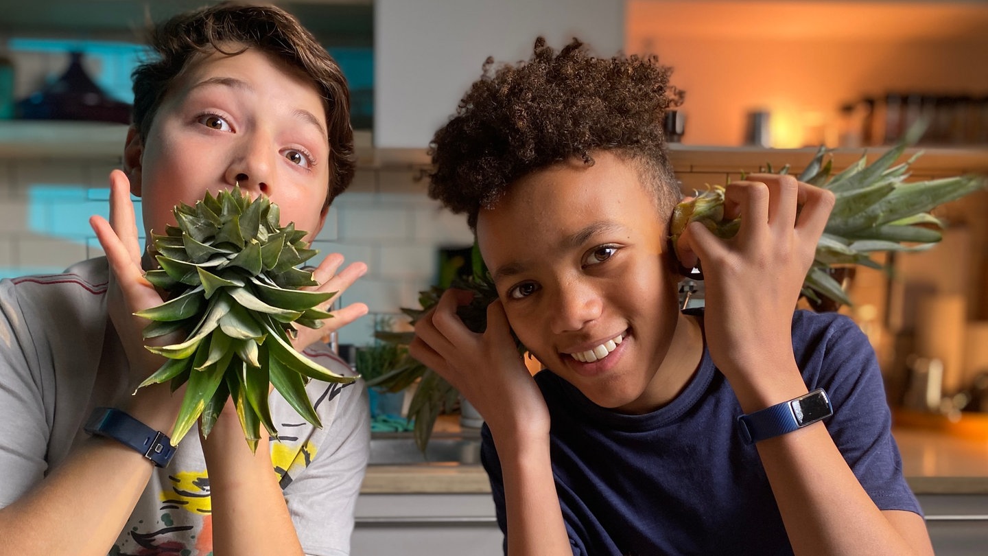 Vasko und Enes testen Ananas-Schneidetechniken (Foto: SWR, Marike Hoppe)