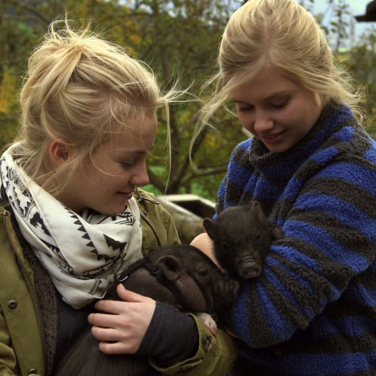 Nelly und Lilie mit Schweinchen auf dem Arm. (Foto: SWR)