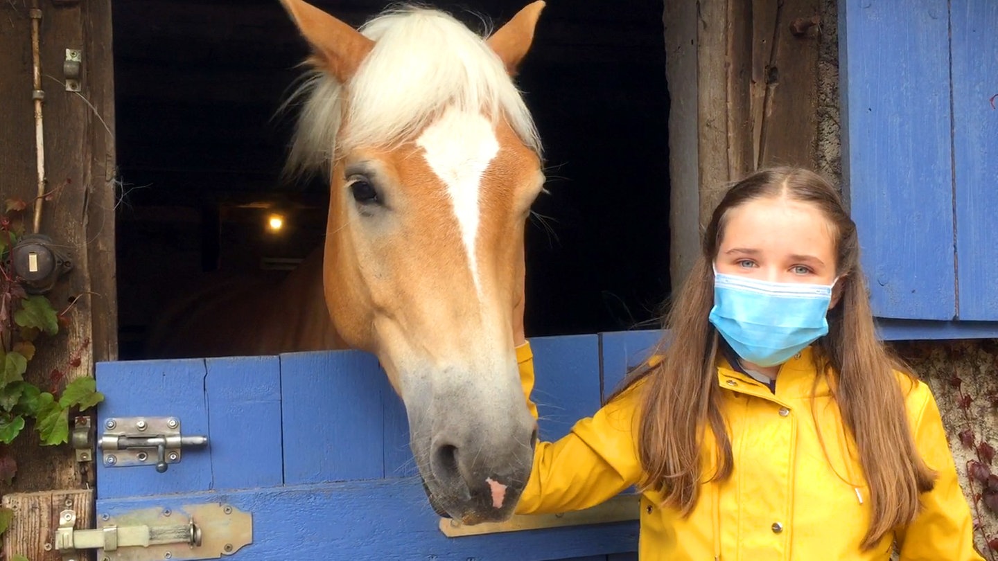 Paulina alias Lucy streichelt ein Pferd am Reiterhof (Foto: SWR)