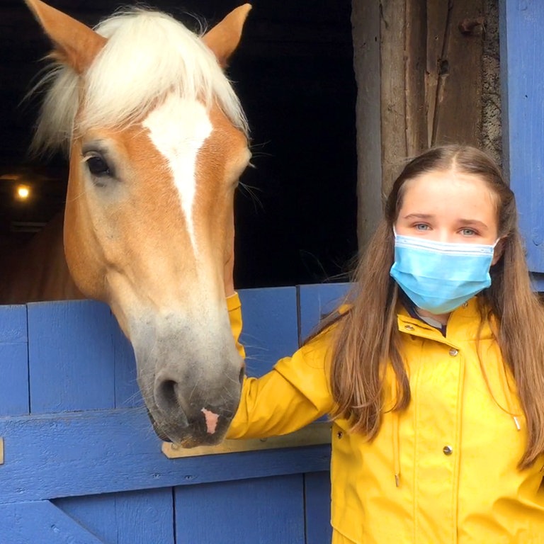 Paulina alias Lucy streichelt ein Pferd am Reiterhof (Foto: SWR)