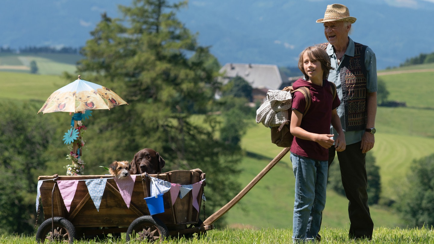 Ein Junge zieht mit seinem Opa einen Bollerwagen in dem zwei Hunde sitzen (Foto: SWR, Maria Wiesler)