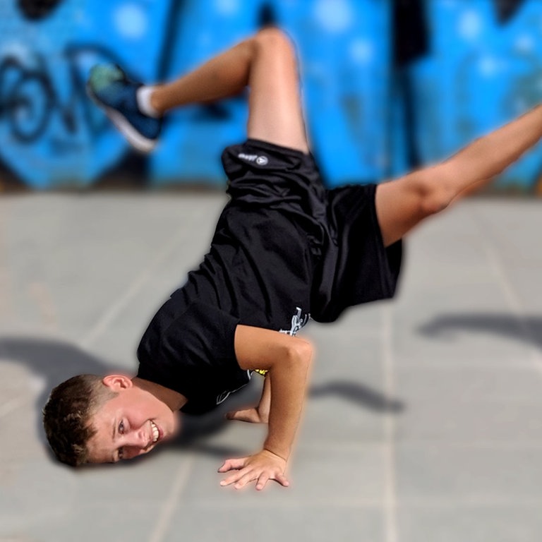 Jalil macht auf dem Boden eine Capoeira-Figur, Luka steht im Trikot daneben und hält einen Fußball in der Hand (Foto: SWR)