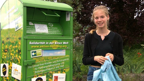 Tigerenten-Reporterin Juli vor einem Altkleidercontainer (Foto: SWR)