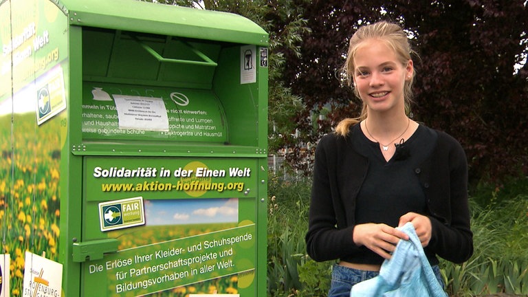 Tigerenten-Reporterin Juli vor einem Altkleidercontainer (Foto: SWR)