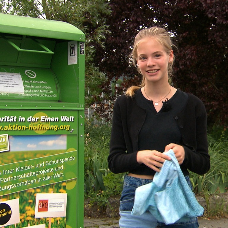 Tigerenten-Reporterin Juli vor einem Altkleidercontainer (Foto: SWR)