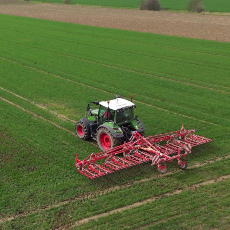 Traktor fährt auf einem Feld