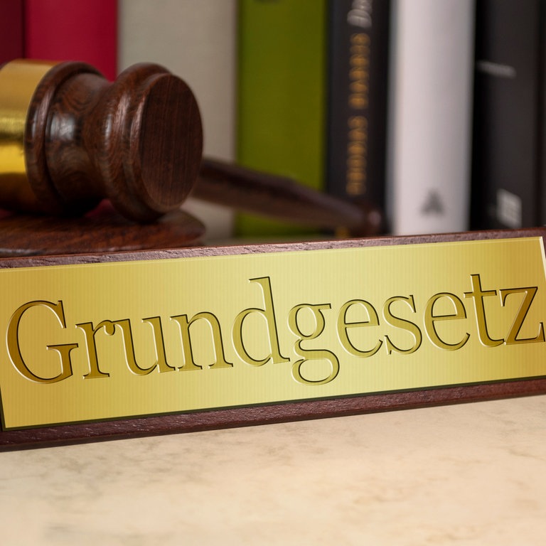 Grundgesetzschild und ein Hammer (Foto: Colourbox)