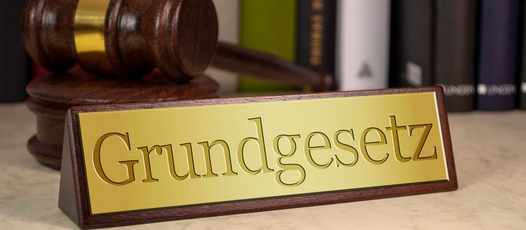 Grundgesetzschild und ein Hammer (Foto: Colourbox)