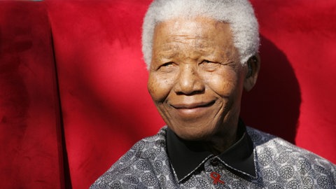Nelson Mandela sitzt in einem roten Sessel (Foto: dpa Bildfunk, dpa Picture-Alliance)