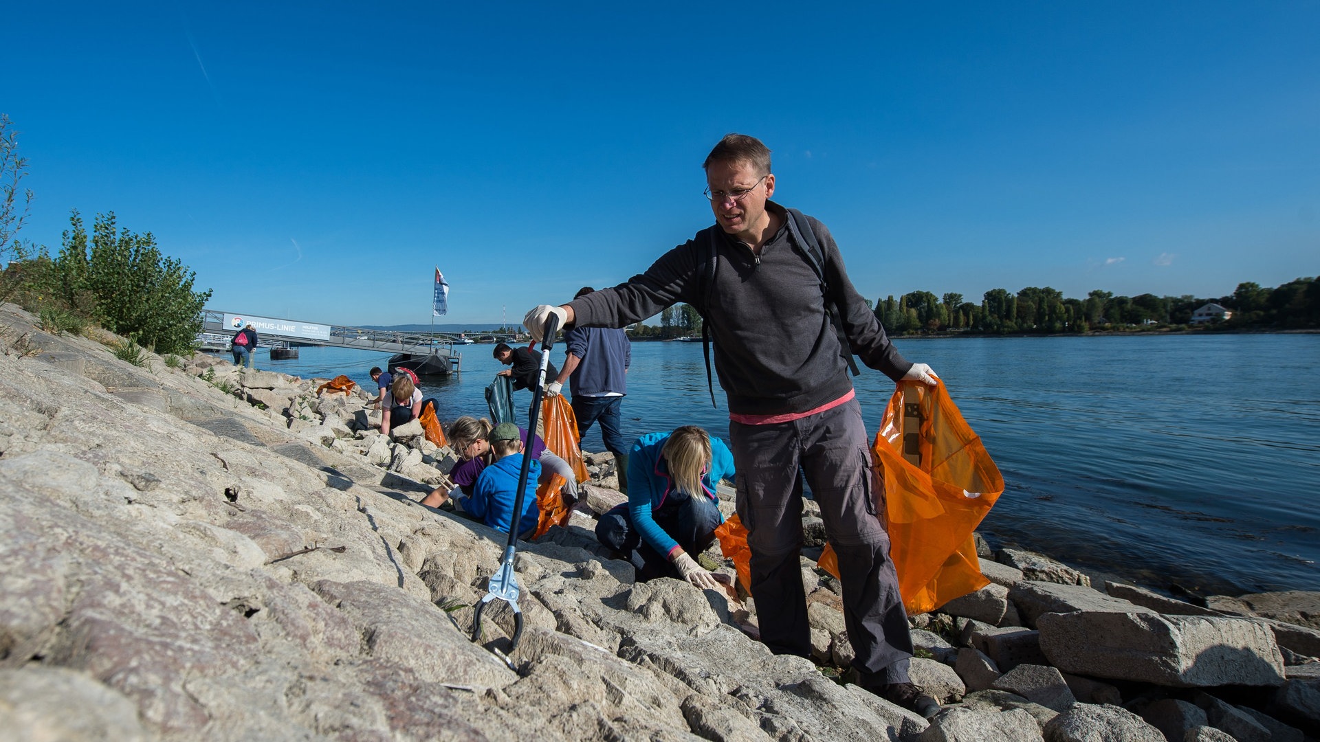 Foto: picture-alliance / Reportdienste, picture alliance/dpa | Silas Stein Ehrenamtliche sammeln bei der Umweltinitiative «Rhein Cleanup» am Rheinufer Müll. (Foto: picture-alliance / Reportdienste, picture alliance/dpa | Silas Stein)