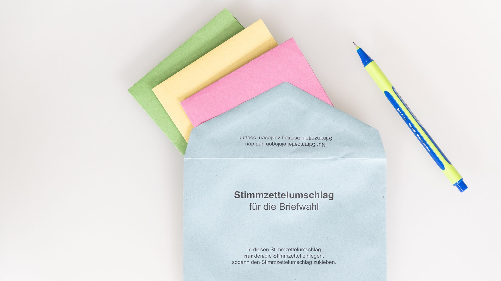 Verschiedene Stimmzettel stecken in einem Stimmzettelumschlag für die Briefwahl.  (Foto: picture-alliance / Reportdienste, picture alliance/dpa | Friso Gentsch)