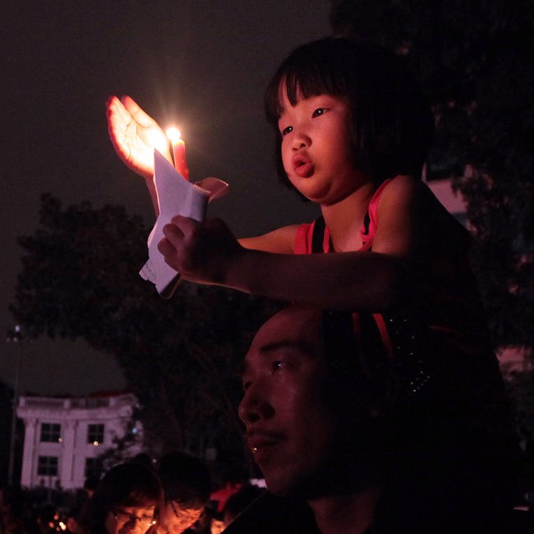 Ein Mädchen hält während der "Earth Hour" eine Kerze hoch. (Foto: picture-alliance / Reportdienste, dpa picture-alliance)
