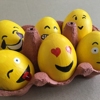 Gelbe Ostereier in Eierpappe mit Smileys.