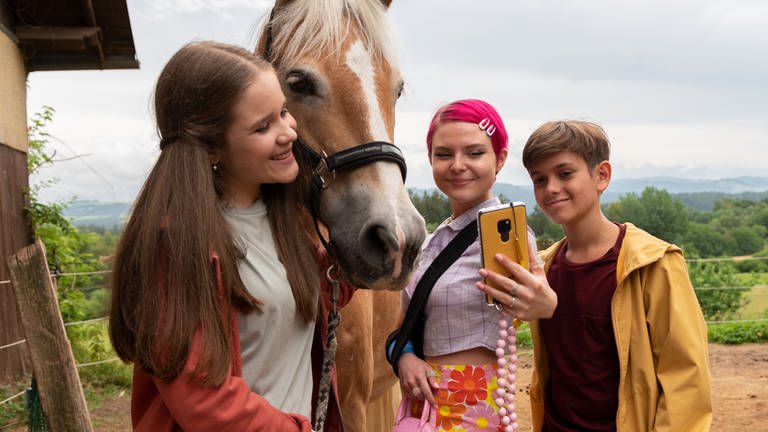 Zwei Mädchen und ein Junge machen ein Pferde-Selfie (Foto: SWR, Maria Wiesler)