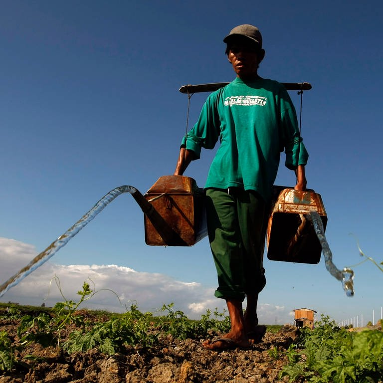 Ein philippinischer Bauer bewässert seine trockenen Felder